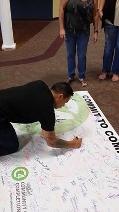 A CCC student signs the C4 banner during 2014's event.